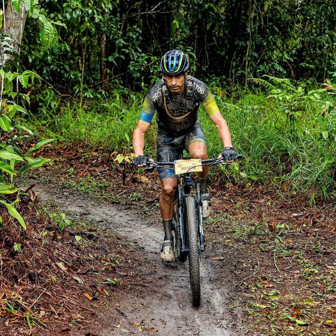 Ciclista EDRO em trilha fechada com lama, em prova