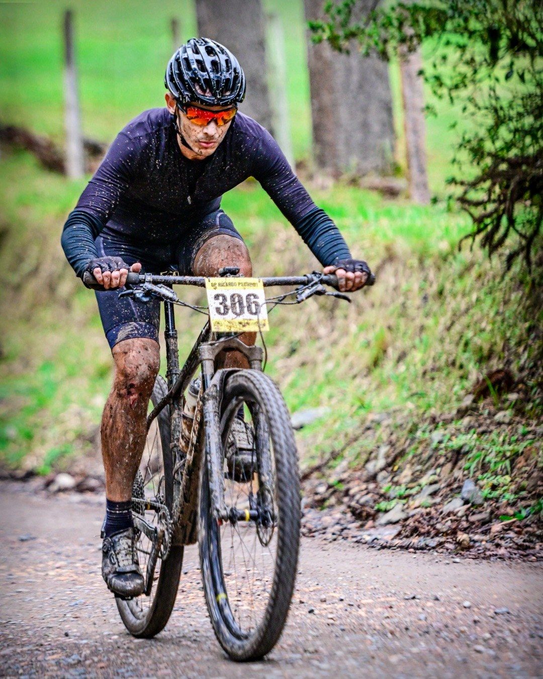Ciclista EDRO em prova de mountain bike, com placa de competição
